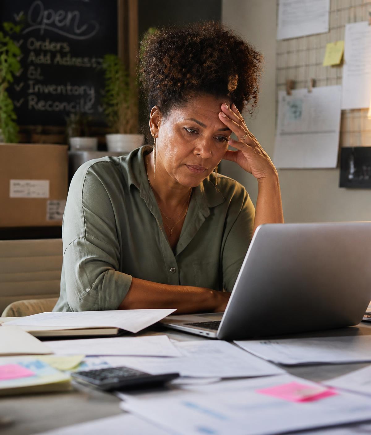 A small business owner reviewing paperwork at her desk